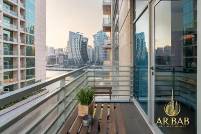 a bench on a balcony with a view of a city at Hamilton Residence - Luxury 1BR - Stunning Dubai Canal View - Near Dubai Mall & Burj Khalifa in Dubai