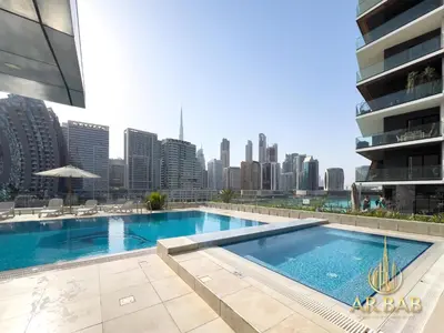 a swimming pool with a city skyline in the background at Hamilton Residence - Luxury 1BR - Stunning Dubai Canal View - Near Dubai Mall & Burj Khalifa in Dubai