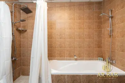 a bathroom with a bath tub with a shower curtain at Hamilton Residence - Luxury 1BR - Stunning Dubai Canal View - Near Dubai Mall & Burj Khalifa in Dubai