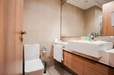 a bathroom with a sink and a toilet and a mirror at Cozy Studio with Garden Views in Nad Al Sheba in Dubai