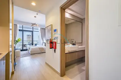 a bathroom with a sink and a bed and a mirror at Cozy Studio in Azizi Riviera 3, Al Merkadh by Deluxe Holiday Homes in Dubai