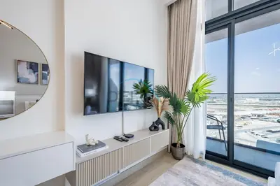 a living room with a tv and a large window at Cozy Studio in Azizi Riviera 3, Al Merkadh by Deluxe Holiday Homes in Dubai