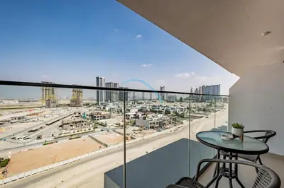 a balcony with a table and a view of a city at Cozy Studio in Azizi Riviera 3, Al Merkadh by Deluxe Holiday Homes in Dubai