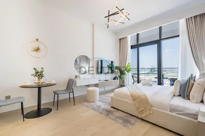 a white bedroom with a large bed and a desk at Cozy Studio in Azizi Riviera 3, Al Merkadh by Deluxe Holiday Homes in Dubai