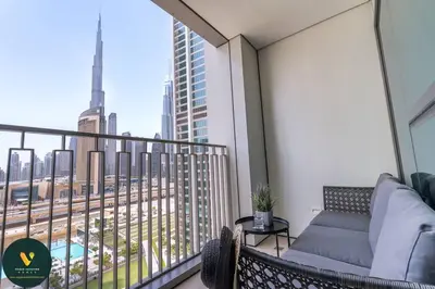 a balcony with a couch and a view of a city at Vogue Downtown Views II with Direct Access to Dubai Mall Via a Climate Controlled Bridge, Two Bedroom Apartment with Balcony and Burj Khalifa View in Dubai
