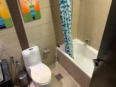 a bathroom with a toilet and a bath tub at Cozy 1BHK Apartment-Dubai Marina in Dubai
