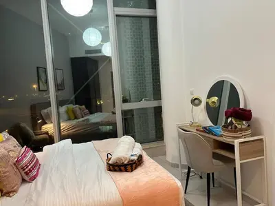 a bedroom with a bed and a desk and a mirror at Cozy 1BHK Apartment-Dubai Marina in Dubai