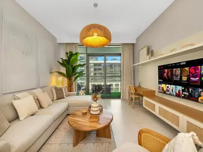 a living room with a couch and a tv at Chic 1 Bedroom on Private Beach in Dubai Harbour in Dubai