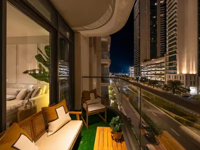 a balcony with a couch and a view of a city at Chic 1 Bedroom on Private Beach in Dubai Harbour in Dubai