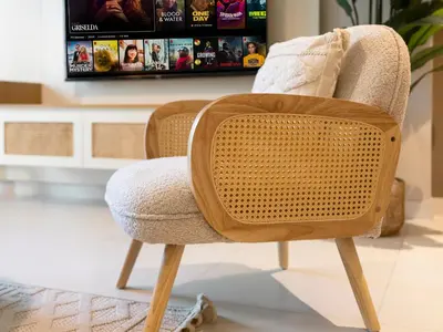 a wicker chair in a living room with a tv at Chic 1 Bedroom on Private Beach in Dubai Harbour in Dubai
