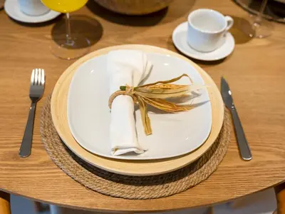 a table with a plate with a napkin and fork and knife at Chic 1 Bedroom on Private Beach in Dubai Harbour in Dubai