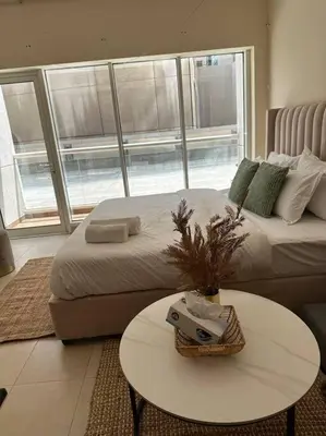 a bedroom with a bed and a table and a couch at Luxury Studio Near Burj Khalifa in Dubai