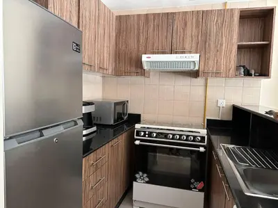 a kitchen with stainless steel appliances and wooden cabinets at Luxury Studio Near Burj Khalifa in Dubai
