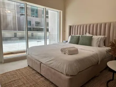 a bedroom with a large bed with a large window at Luxury Studio Near Burj Khalifa in Dubai