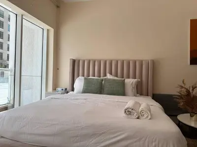 a large white bed with two towels on it at Luxury Studio Near Burj Khalifa in Dubai