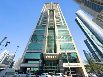 a tall building with cars parked in front of it at High-floor 2BR at Palladium, JLT - Near Metro in Dubai