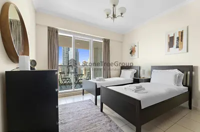 a bedroom with two beds and a mirror at High-floor 2BR at Palladium, JLT - Near Metro in Dubai
