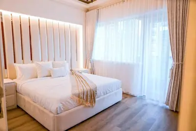 a bedroom with a white bed and a large window at The Nest by Beds & Company in Dubai