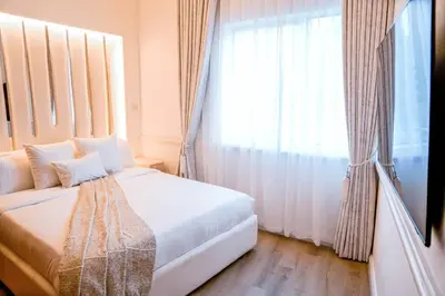 a bedroom with a white bed and a large window at The Nest by Beds & Company in Dubai