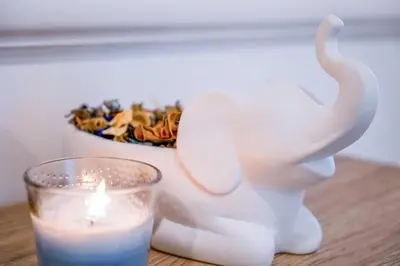 a candle and a white statue next to a candle at The Nest by Beds & Company in Dubai