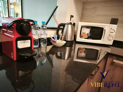 a kitchen counter with a coffee maker and a microwave at La Riviera Serenity in Dubai