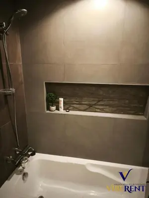 a bathroom with a white bath tub with a plant at La Riviera Serenity in Dubai