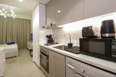 a small kitchen with a sink and a microwave at NewArabian Azizi Riviera Studio in Dubai