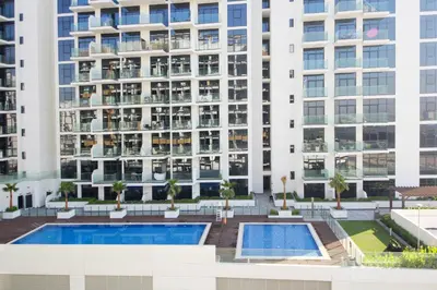 an aerial view of a building with two pools at NewArabian Azizi Riviera Studio in Dubai
