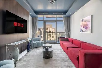a living room with a red couch and a tv at Stunning Burj Khalifa View 5 Star Hotel Amenities in Dubai