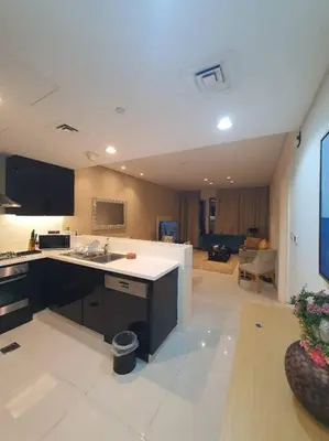 a large kitchen with a sink and a living room at damac maison canal view Luxuary 1BHK in heart downtow in Dubai
