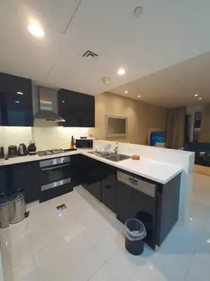 a large kitchen with a large white counter top at damac maison canal view Luxuary 1BHK in heart downtow in Dubai