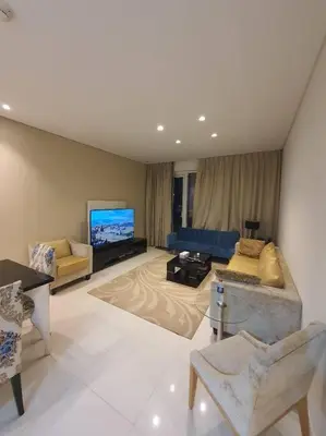a large living room with a couch and a tv at damac maison canal view Luxuary 1BHK in heart downtow in Dubai