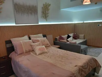 a bedroom with a large bed and a couch at Cosy Studio Marina in Dubai