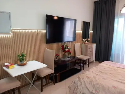 a hotel room with a bed and a television on the wall at Cosy Studio Marina in Dubai