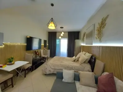 a bedroom with a bed and a table and a couch at Cosy Studio Marina in Dubai