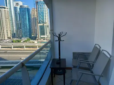 a balcony with two chairs and a view of a city at Cosy Studio Marina in Dubai