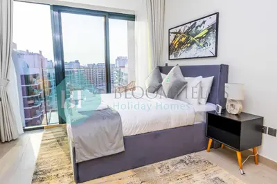 a bedroom with a bed and a large window at Bloomfields Modern Stu In Azizi Riviera in Dubai