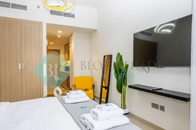 a bedroom with a bed and a flat screen tv at Bloomfields Modern Stu In Azizi Riviera in Dubai