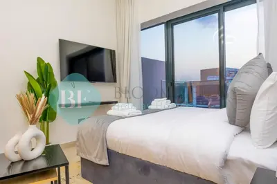 a bedroom with a large bed with a large window at Bloomfields Modern Stu In Azizi Riviera in Dubai