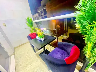 a living room with two chairs and a table at Brand New Studio Near ADCB Metro in Dubai