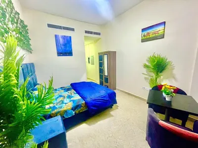 a bedroom with a bed and a table and plants at Brand New Studio Near ADCB Metro in Dubai