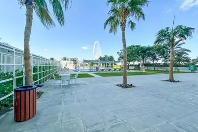 a patio with palm trees and a trash can at Al Bateen Residences, JBR- Stunning 2-BR Apartment with Sea View in Dubai