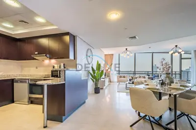 a kitchen and living room with a table and chairs at Stylish 2BR in Sky Gardens, DIFC by Deluxe Holiday Homes in Dubai