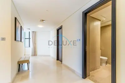 a hallway with a door to a bathroom with a toilet at Stylish 2BR in Sky Gardens, DIFC by Deluxe Holiday Homes in Dubai