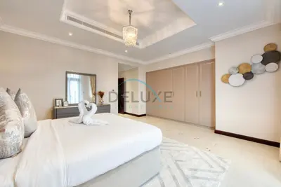 a bedroom with a white bed with a swan on it at Immaculate 4BR Villa with Assistant Room and Private Pool at Frond O Palm Jumeirah by Deluxe Holiday Homes in Dubai