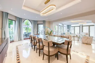 a dining room with a glass table and chairs at Immaculate 4BR Villa with Assistant Room and Private Pool at Frond O Palm Jumeirah by Deluxe Holiday Homes in Dubai