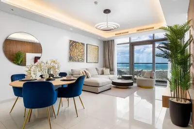 a living room with a table and blue chairs at Spectacular 2 Bed Downtown I Highest Infiniti Pool in Dubai