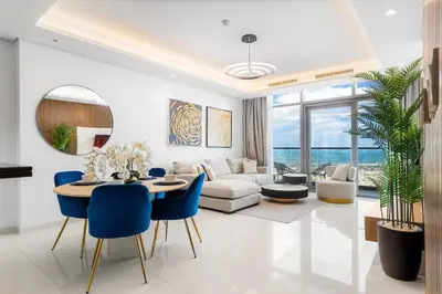 a living room with a table and blue chairs at Spectacular 2 Bed Downtown I Highest Infiniti Pool in Dubai
