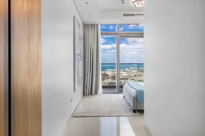 a bedroom with a bed and a view of the ocean at Spectacular 2 Bed Downtown I Highest Infiniti Pool in Dubai