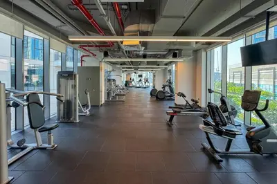 a gym with several treadmills and cardio machines at Luxe Living in 1 Bedroom apartment at 17 Icon Bay in Dubai